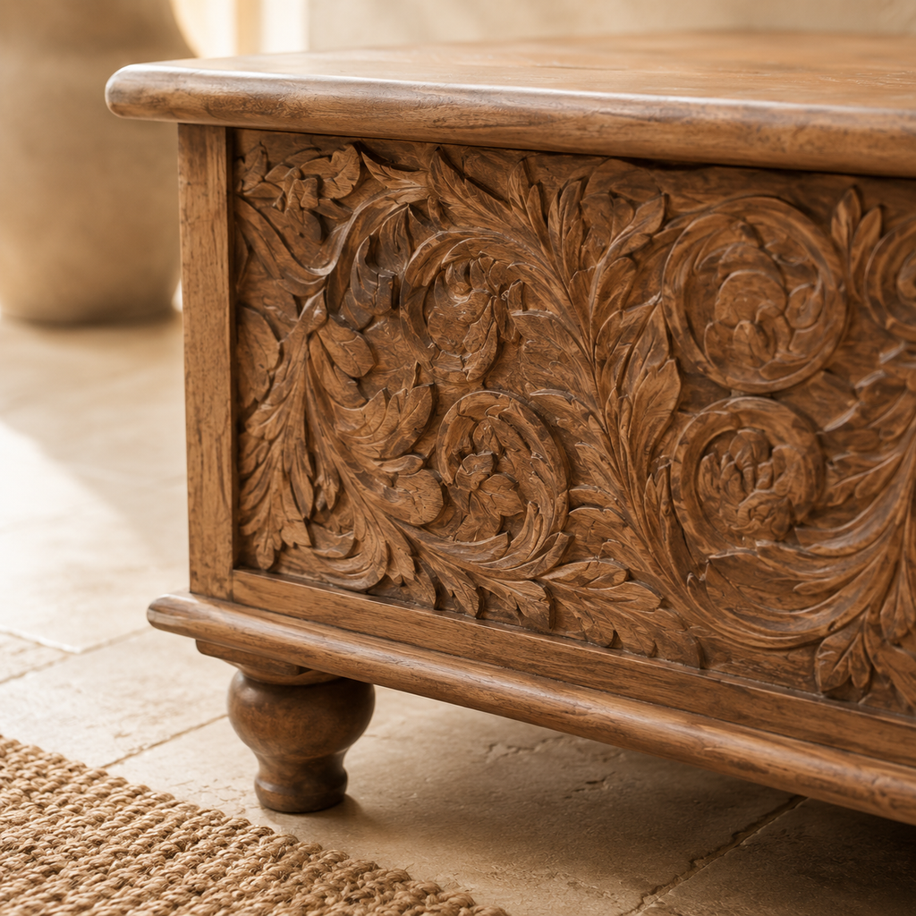 Close-up of forged iron latch and carved floral scrollwork on mango wood trunk front