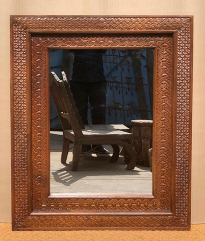 Hand-carved natural mango wood wall mirror with dense all-over petal scale repeat frame and rope-twist inner border