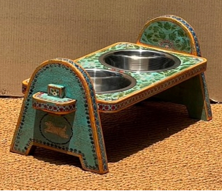 Hand-painted Rajasthani mango wood arch-leg elevated dog bowl stand in sage teal green with multicolour tiny floral all-over, yellow dot-work borders and two stainless steel bowls