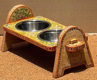 Hand-painted Rajasthani mango wood arch-leg elevated dog bowl stand in butter yellow with multicolour tiny floral all-over, orange-red dot-work borders and two stainless steel bowls