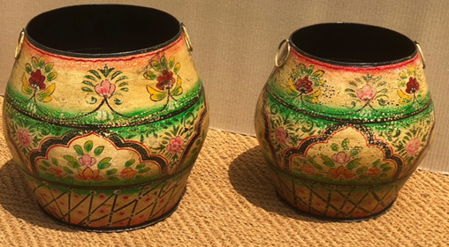 Set of two hand-painted metal round belly planters in ivory cream with multicolour pink floral, medallion arch cartouche panels, green dot-work shoulder band, dark crosshatch base and brass ring handles