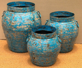 Set of three distressed iron pots in heavily cracked and chipped sky blue turquoise finish revealing rust and raw iron underneath, wide-shouldered barrel form with wide open rim and two small iron loop handles each