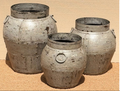 Set of three distressed iron pots in heavily cracked and chipped silver-grey chalky finish with horizontal ribbing, central iron ring pull and wide open rim