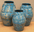 Set of three distressed iron barrel pots in heavily cracked and chipped sky blue turquoise finish with vertical stave panels, horizontal hoop banding at shoulder and mid-body, and small iron ring handles on each side