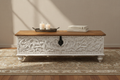 Hand-carved whitewash storage trunk – front hero as coffee table in warm living room