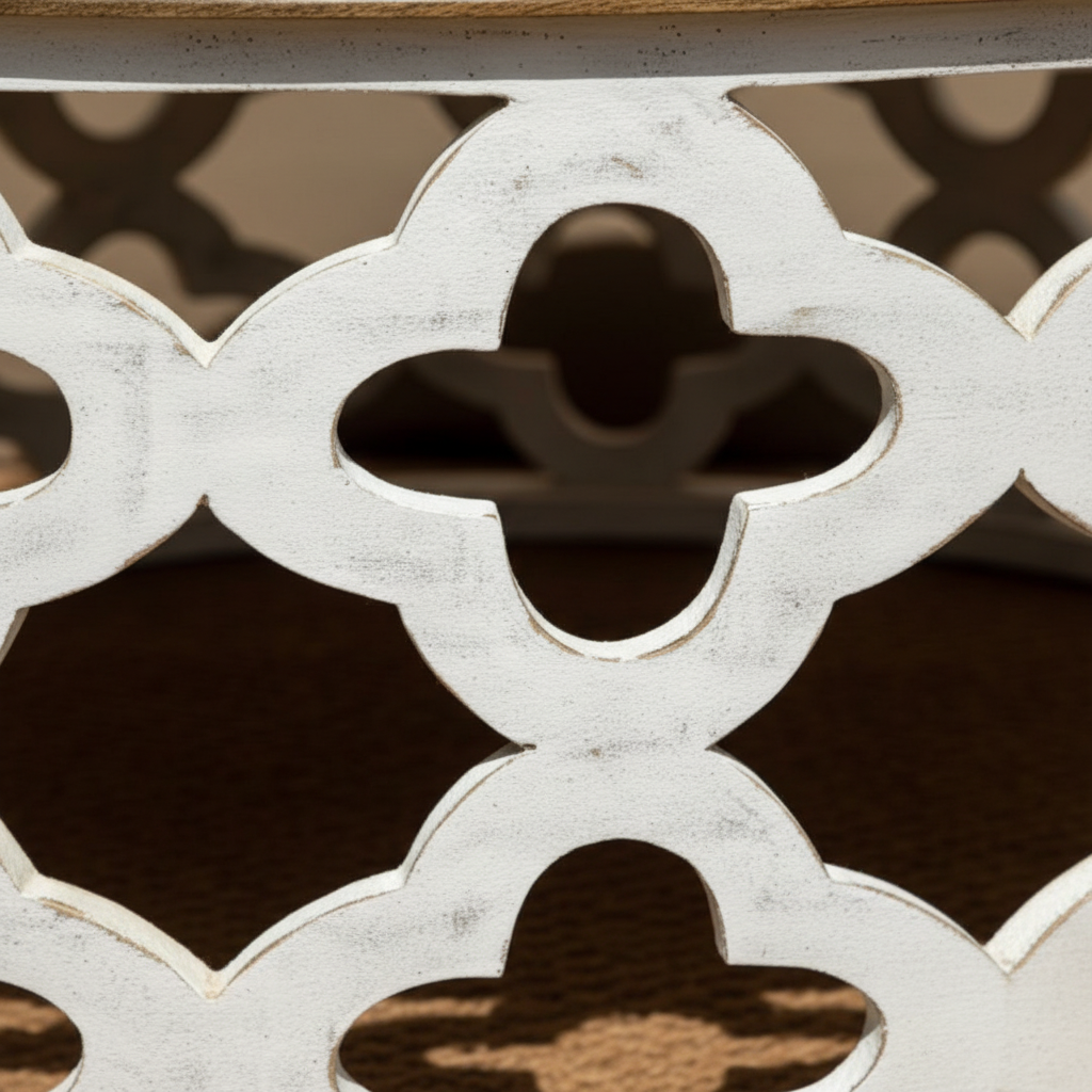 Close-up of open Moroccan quatrefoil lattice cutwork on antique white drum base
