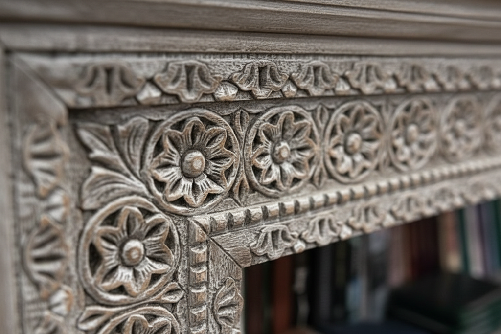 Close-up of hand-carved all-over dense floral and leaf motifs on grey whitewash console frame