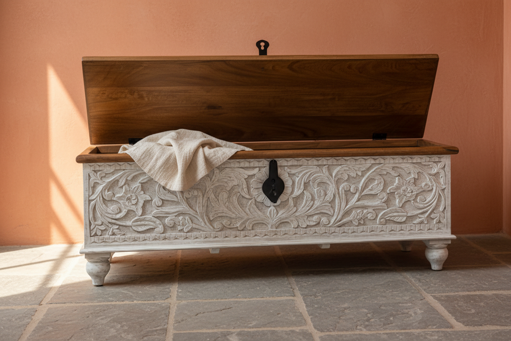 Hand-carved whitewash storage trunk – lid open with linen throw in warm entryway